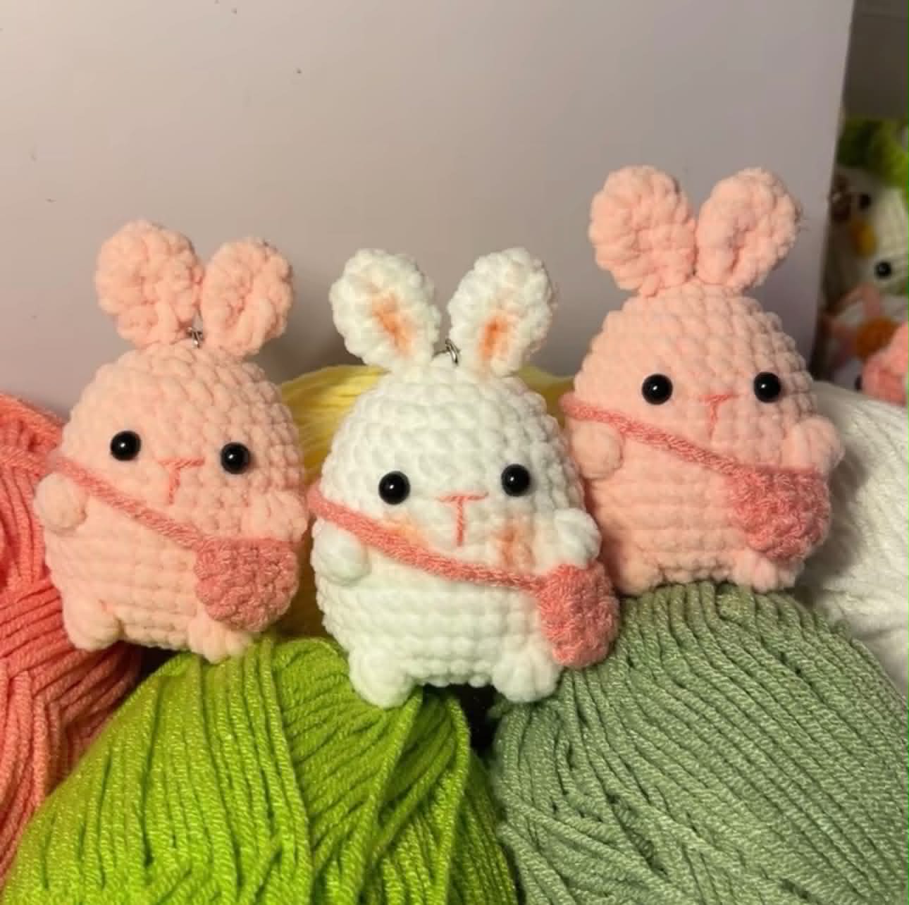 Móc khóa gấu crochet handmade với khoen vàng trên nền hồng nhạt